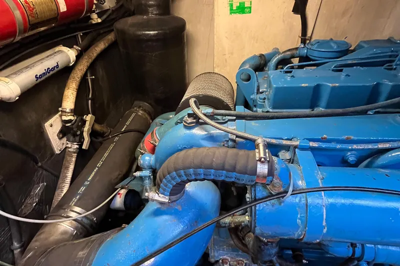 Slide: The Image of Engine compartment of a 1994 Tiara Yachts 4000 Express, featuring blue machinery and hoses. - 25