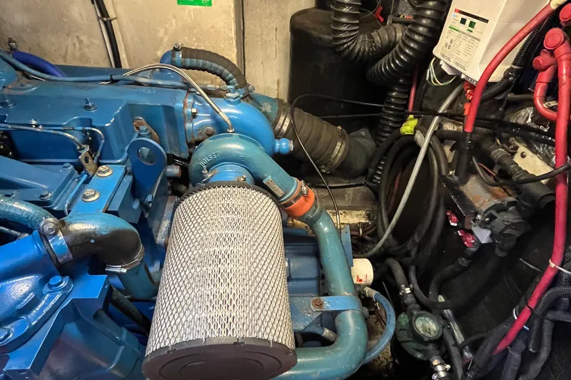 Slide: The Image of Engine compartment of a 1994 Tiara Yachts 4000 Express, showcasing blue machinery and wiring. - 26
