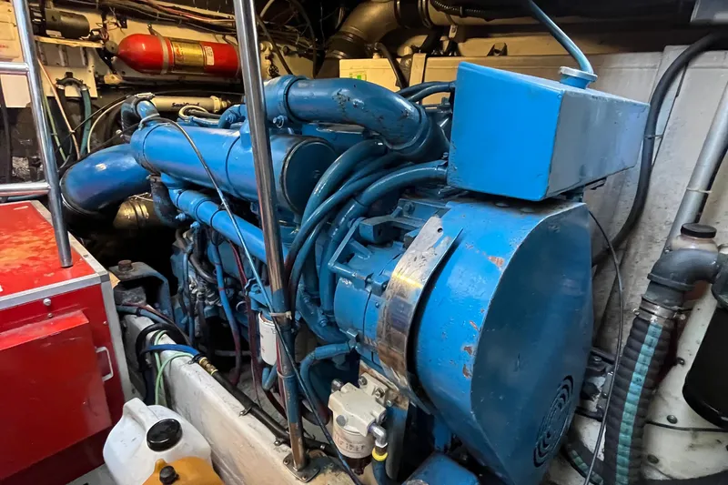 Slide: The Image of Engine room of a 1994 Tiara Yachts 4000 Express, featuring a blue marine engine. - 30