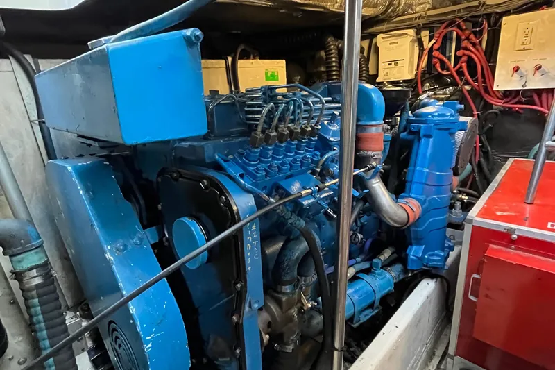 Slide: The Image of Engine room of a 1994 Tiara Yachts 4000 Express, featuring a blue marine engine. - 31