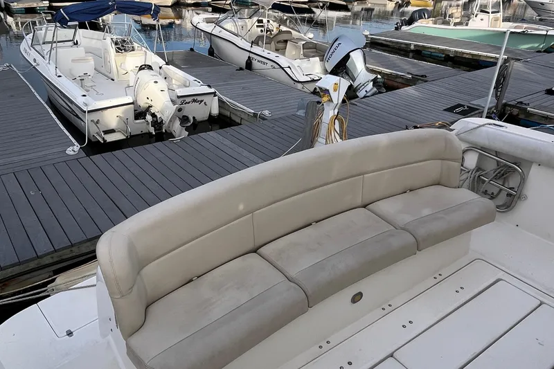 Slide: The Image of 1994 Tiara Yachts 4000 Express with beige seating at a marina dock. - 34