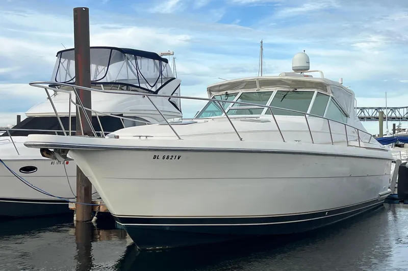 Slide: The Image of 1994 Tiara Yachts 4000 Express docked at marina, showcasing sleek design and spacious deck. - 5