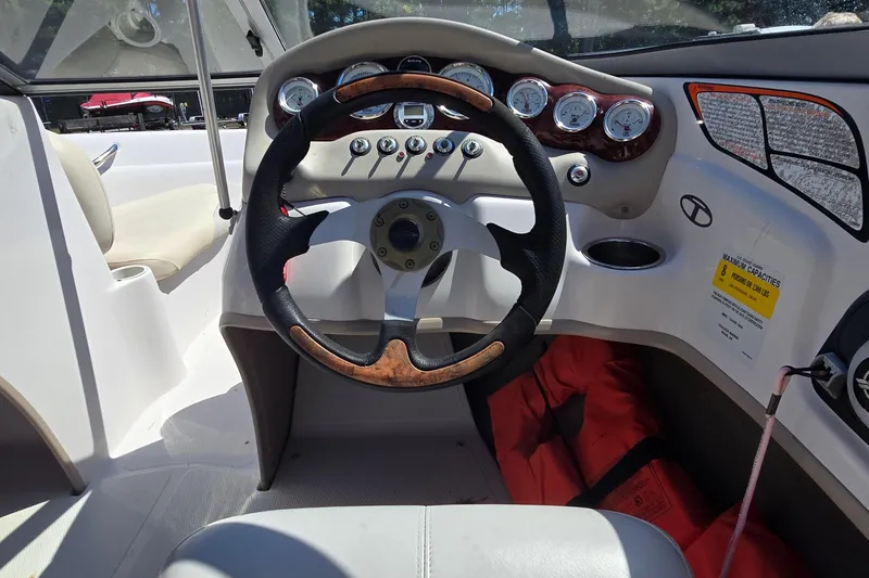 Slide: The Image of Steering wheel and dashboard of a 2011 Tahoe Q5i boat, featuring gauges and controls. - 10