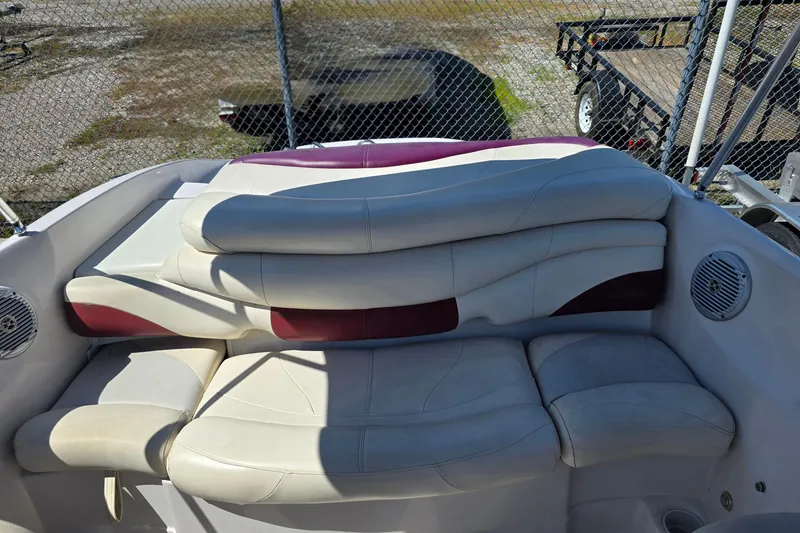 Slide: The Image of 2011 Tahoe Q5i boat interior with white and maroon seating, outdoor setting. - 25