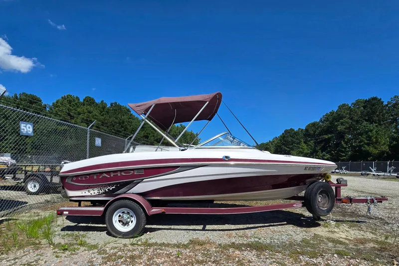 Slide: The Image of 2011 Tahoe Q5i boat on trailer, parked outdoors under clear blue sky. - 5