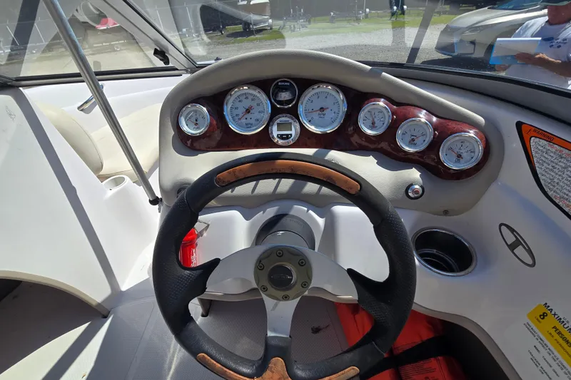 Slide: The Image of Steering wheel and dashboard of a 2011 Tahoe Q5i boat with gauges and controls. - 9