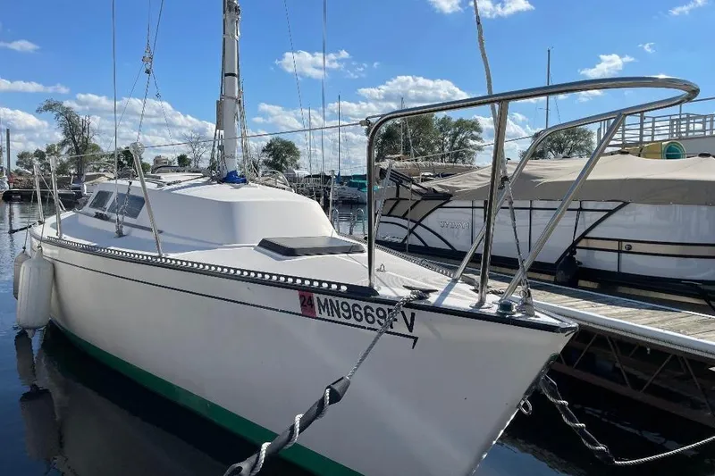 The Image of 1985 S2 K sailboat docked at marina under blue sky. - 0