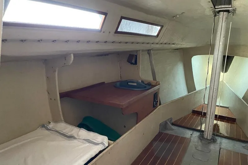 Slide: The Image of 1985 S2 K sailboat interior with wooden accents and sleeping area. - 12