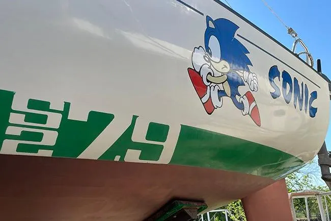 Slide: The Image of 1985 S2 K sailboat deck view, docked, showcasing rigging and hatch. - 5