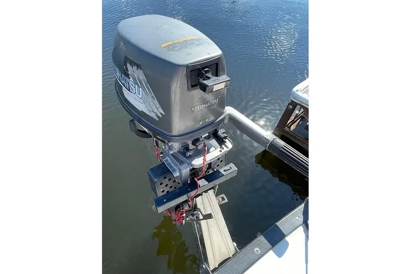 Slide: The Image of 1985 S2 K outboard motor mounted on a boat, reflecting on calm water. - 8