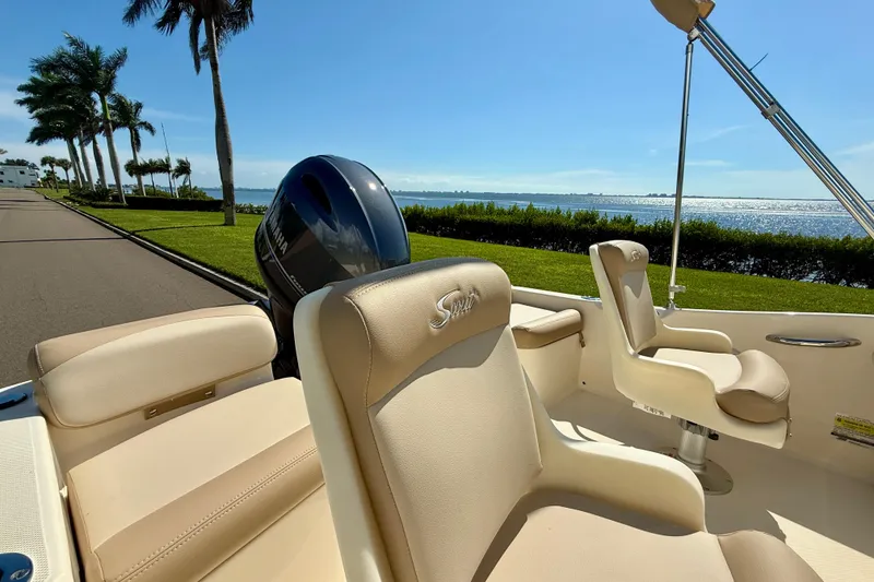 Slide: The Image of 2026 Scout 175 Sport Dorado boat interior with beige seating, scenic waterfront view. - 12