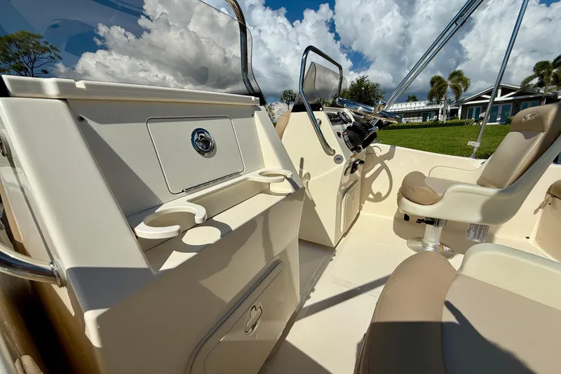 Slide: The Image of 2026 Scout 175 Sport Dorado boat interior with beige seating and steering console. - 14