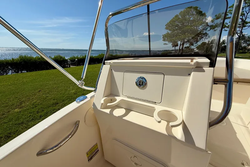 Slide: The Image of 2026 Scout 175 Sport Dorado boat interior with cup holders, near scenic waterfront. - 15