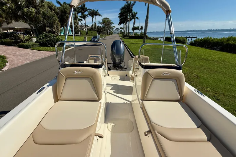 Slide: The Image of 2026 Scout 175 Sport Dorado boat with beige seating, parked near waterfront. - 18