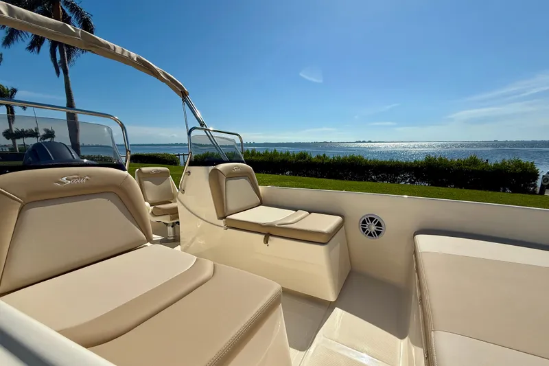 Slide: The Image of 2026 Scout 175 Sport Dorado boat interior with beige seating, overlooking a sunny waterfront. - 19