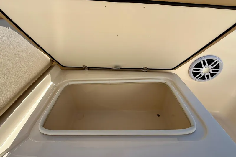 Slide: The Image of Open storage compartment on 2026 Scout 175 Sport Dorado boat, featuring a speaker. - 22