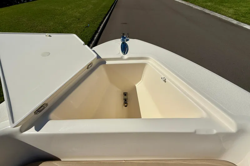 Slide: The Image of Open storage compartment on 2026 Scout 175 Sport Dorado boat, with green grass and road background. - 27