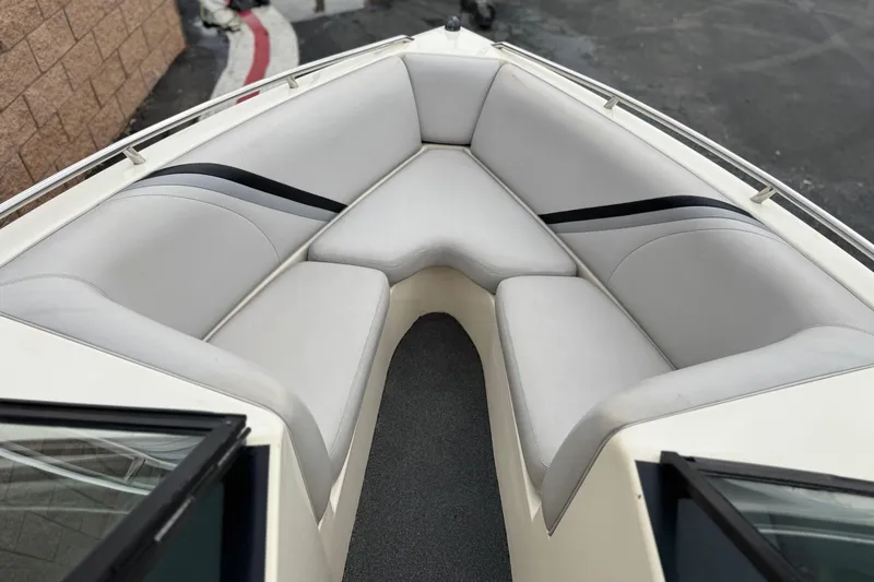 Slide: The Image of 1999 Malibu Sunsetter LX boat interior with gray cushioned seating. - 10