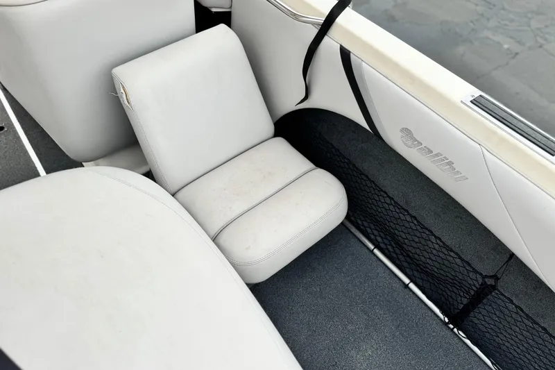 Slide: The Image of 1999 Malibu Sunsetter LX boat interior with white seating and storage net. - 19