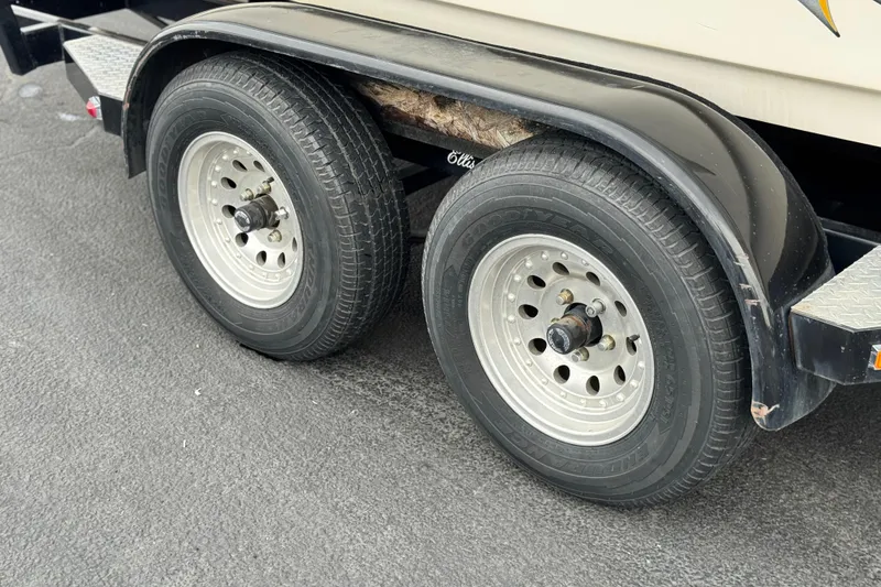 Slide: The Image of Dual wheels on a 1999 Malibu Sunsetter LX trailer, parked on asphalt. - 26