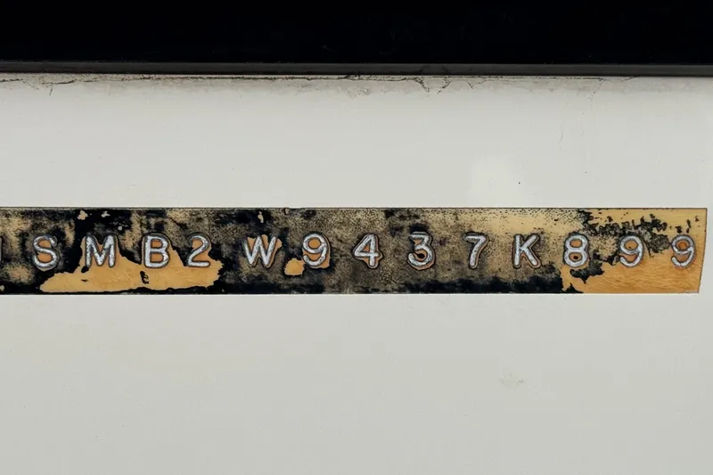 Slide: The Image of 1999 Malibu Sunsetter LX boat hull identification number on weathered surface. - 29