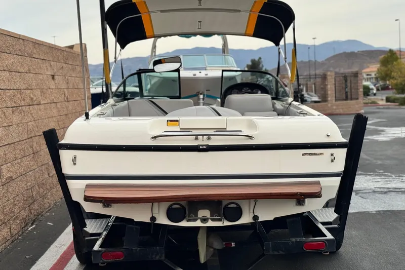 Slide: The Image of 1999 Malibu Sunsetter LX boat with canopy, parked on a trailer, rear view. - 4