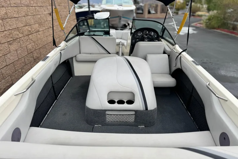 Slide: The Image of 1999 Malibu Sunsetter LX boat interior with white seating and dashboard view. - 8