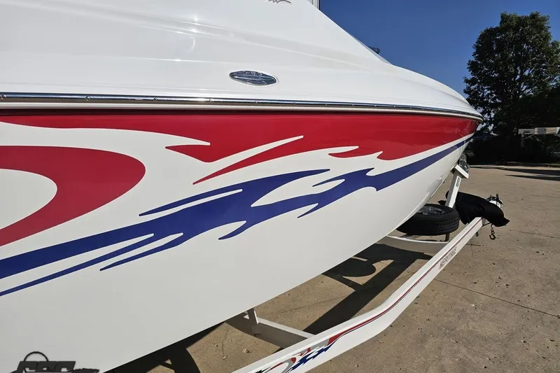 Slide: The Image of 2005 Baja 23 Outlaw boat with red and blue flame graphics on trailer. - 11