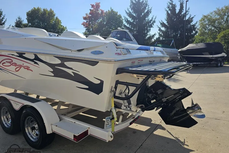Slide: The Image of 2005 Baja 23 Outlaw boat on trailer, parked outdoors in sunny weather. - 30