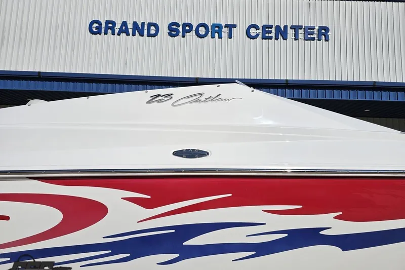 Slide: The Image of 2005 Baja 23 Outlaw boat with vibrant graphics at Grand Sport Center. - 4