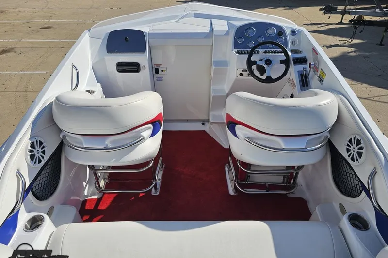 Slide: The Image of 2005 Baja 23 Outlaw boat interior with white seats, red carpet, and sleek dashboard. - 45