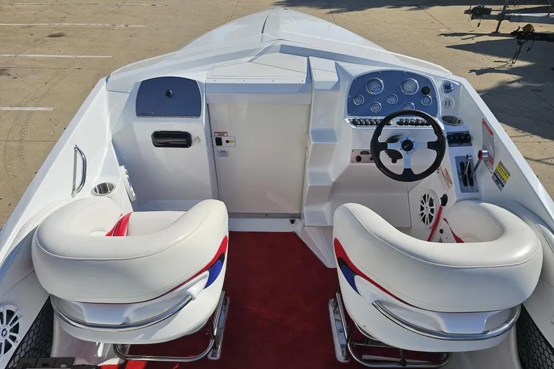 Slide: The Image of 2005 Baja 23 Outlaw boat interior with white seats and modern dashboard controls. - 47