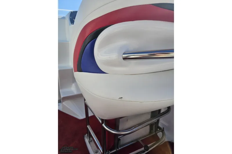 Slide: The Image of 2005 Baja 23 Outlaw boat seat with red, white, and blue upholstery and metal support. - 51