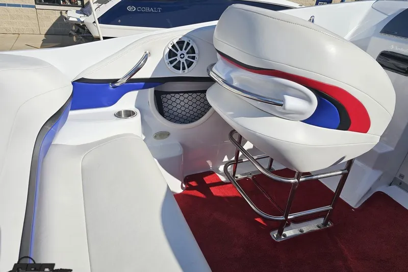 Slide: The Image of 2005 Baja 23 Outlaw boat interior with white seating, red accents, and stainless steel details. - 52
