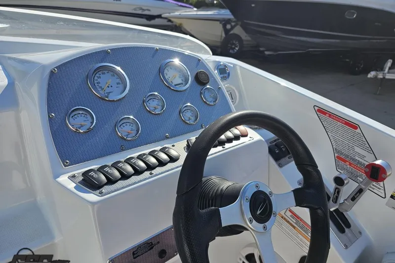 Slide: The Image of 2005 Baja 23 Outlaw boat dashboard with gauges, steering wheel, and control panel. - 59