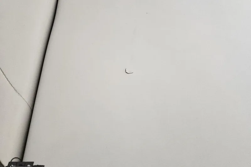 Slide: The Image of White leather upholstery with a small tear, 2005 Baja 23 Outlaw boat interior. - 64