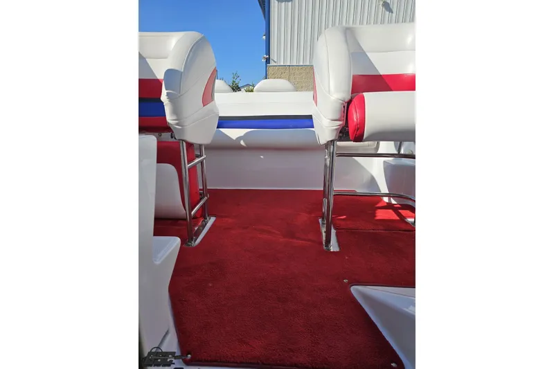 Slide: The Image of 2005 Baja 23 Outlaw boat interior with red carpet and white seats. - 68