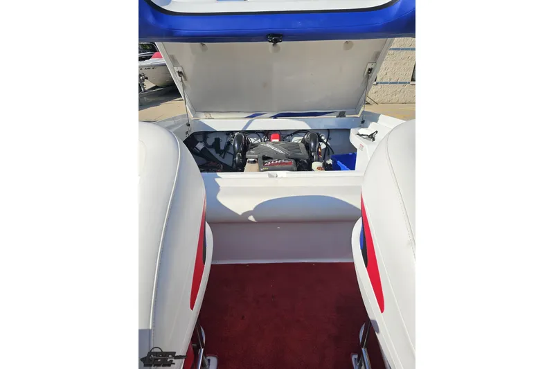 Slide: The Image of 2005 Baja 23 Outlaw boat engine compartment with open hatch, showcasing interior details. - 77