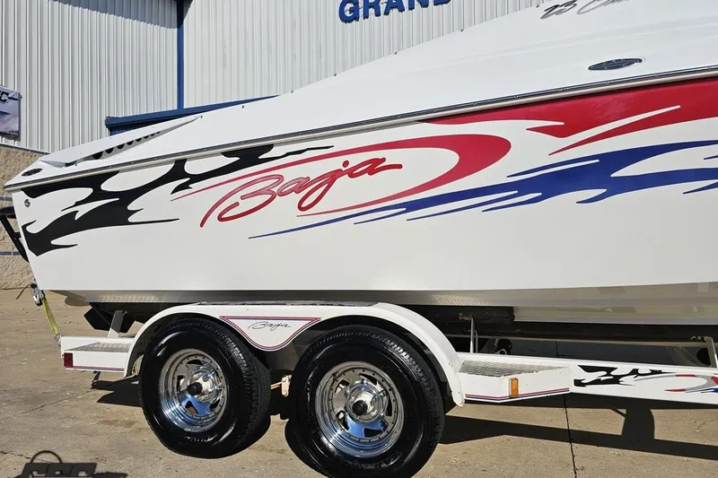 Slide: The Image of 2005 Baja 23 Outlaw boat with vibrant graphics on a trailer. - 8