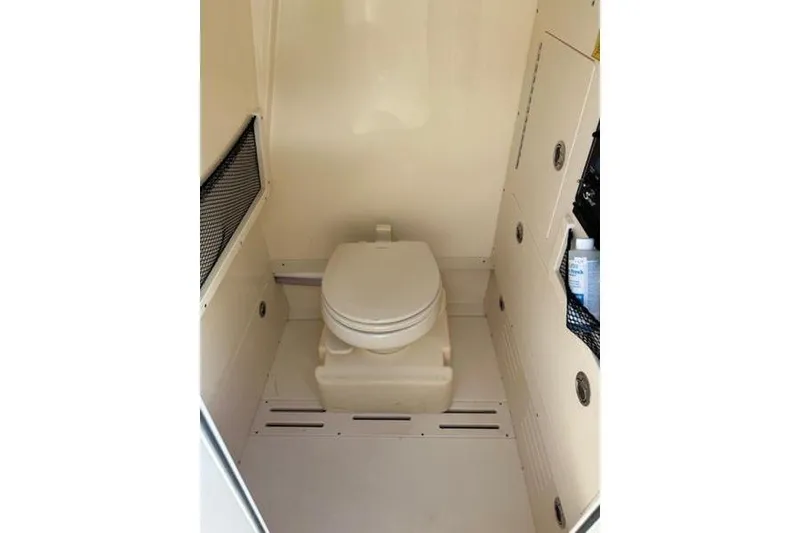 Slide: The Image of 2021 Scout 235 XSF boat interior with compact marine toilet. - 13