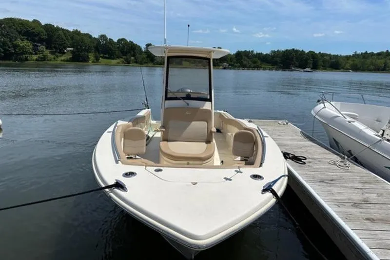 Slide: The Image of 2021 Scout 235 XSF boat docked on a calm lake. - 2