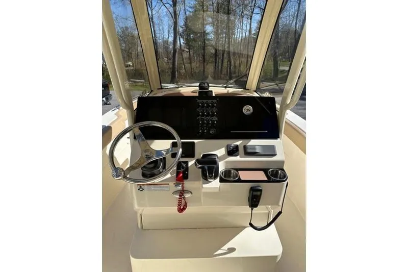 Slide: The Image of 2021 Scout 235 XSF boat dashboard with steering wheel and control panel. - 9