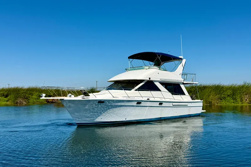 The Image of 1998 Bayliner 3988 Command Bridge Motoryacht cruising on open blue sea. - 0
