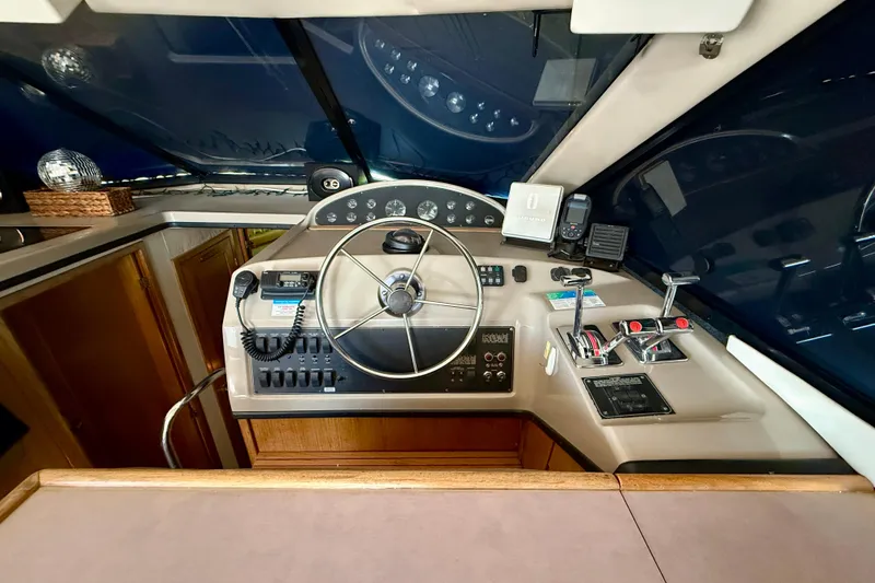 Slide: The Image of 1998 Bayliner 3988 Command Bridge Motoryacht helm with leather seating and navigation controls. - 10