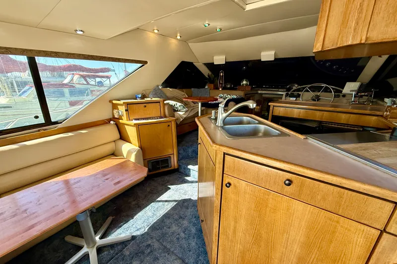 Slide: The Image of 1998 Bayliner 3988 Command Bridge Motoryacht interior with TV and wooden cabinetry. - 20