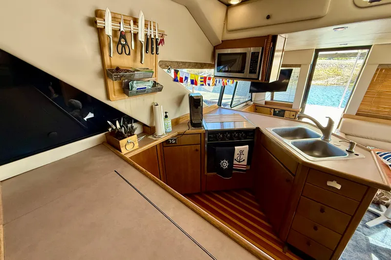 Slide: The Image of Interior of 1998 Bayliner 3988 Command Bridge Motoryacht with wood cabinetry and seating area. - 22
