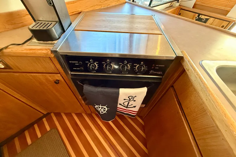 Slide: The Image of 1998 Bayliner 3988 Command Bridge Motoryacht kitchen with sink, stove, and nautical decor. - 23