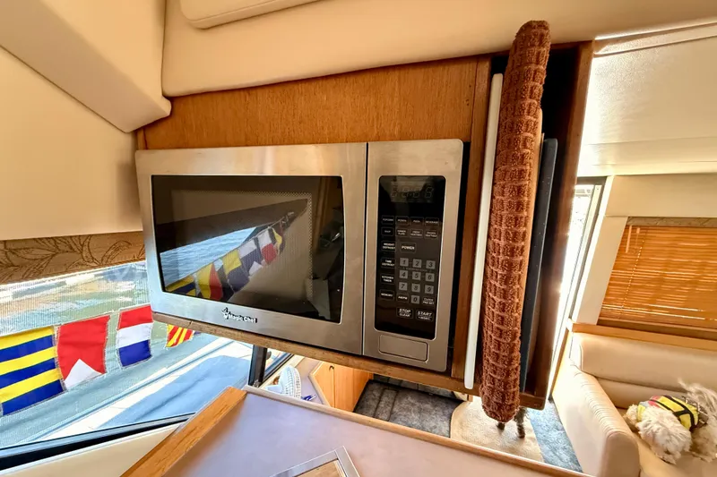 Slide: The Image of 1998 Bayliner 3988 Command Bridge Motoryacht kitchen with wooden cabinetry and dual sinks. - 24