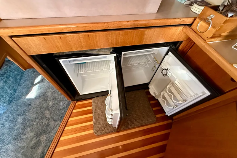 Slide: The Image of 1998 Bayliner 3988 Command Bridge Motoryacht interior with microwave and nautical flags. - 26