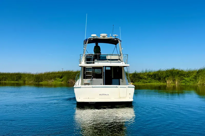 Slide: The Image of 1998 Bayliner 3988 Command Bridge Motoryacht on calm water under clear blue sky. - 6